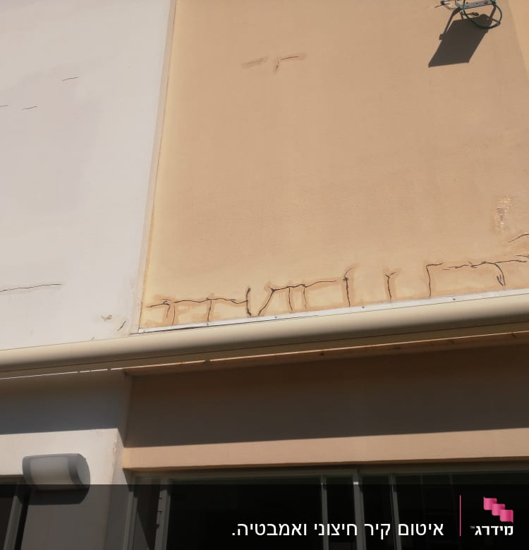 קיר עם סדקים ותיקוני איטום נראים לעין